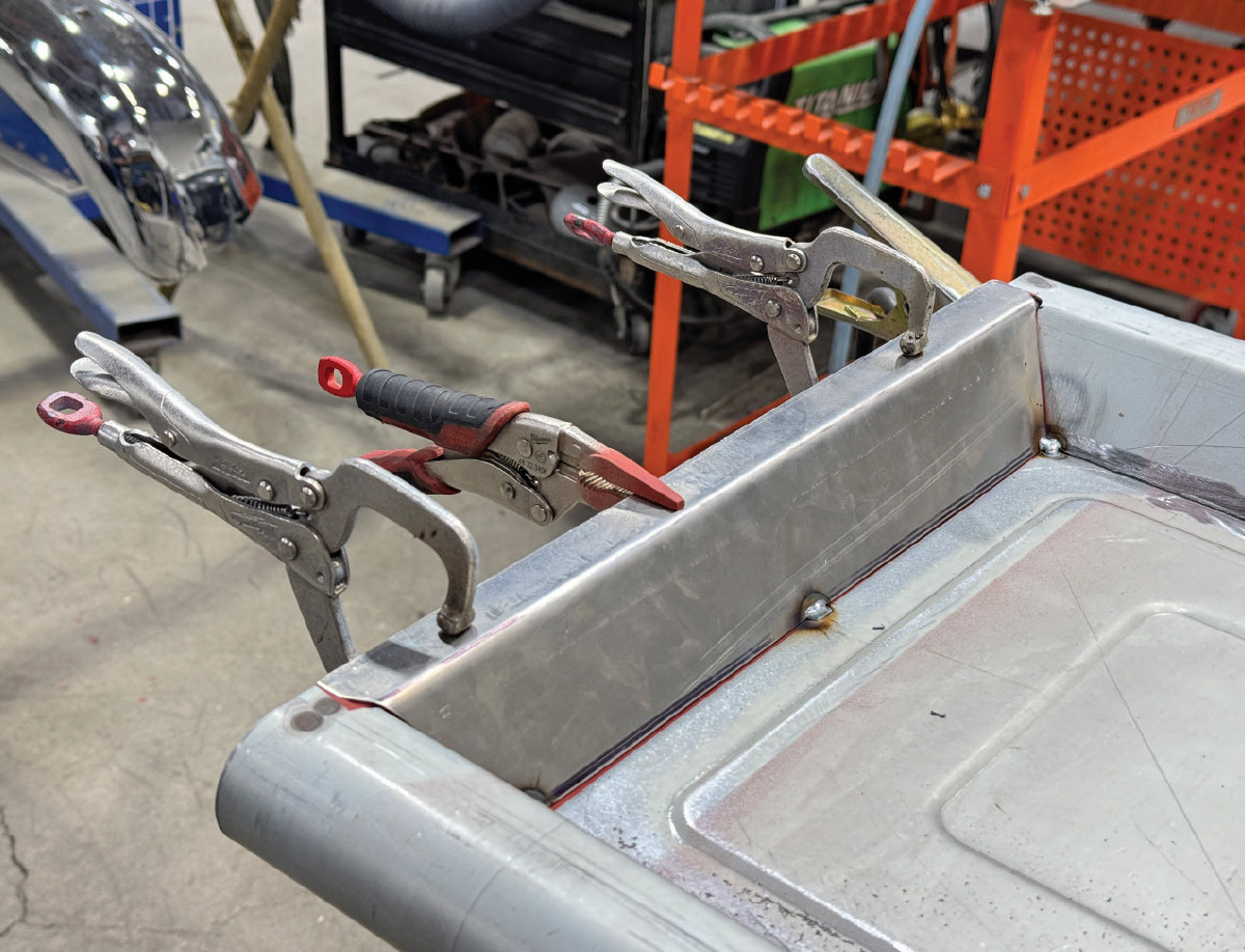 Tailgate edge clamped, three C-clamps plus snips, fresh corner welds