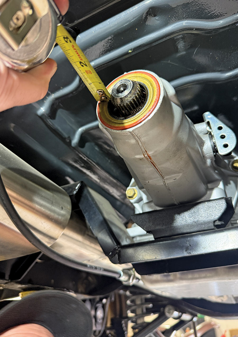 Close-up of a tape measure on an exposed transmission output shaft.