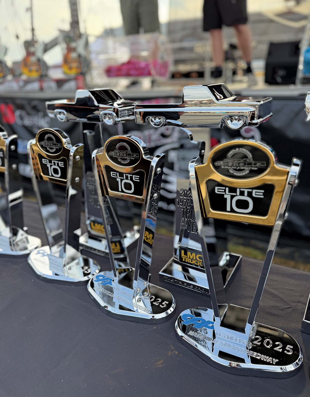  A display of several chrome and gold "Elite 10" trophies, one topped with a miniature chrome custom truck.