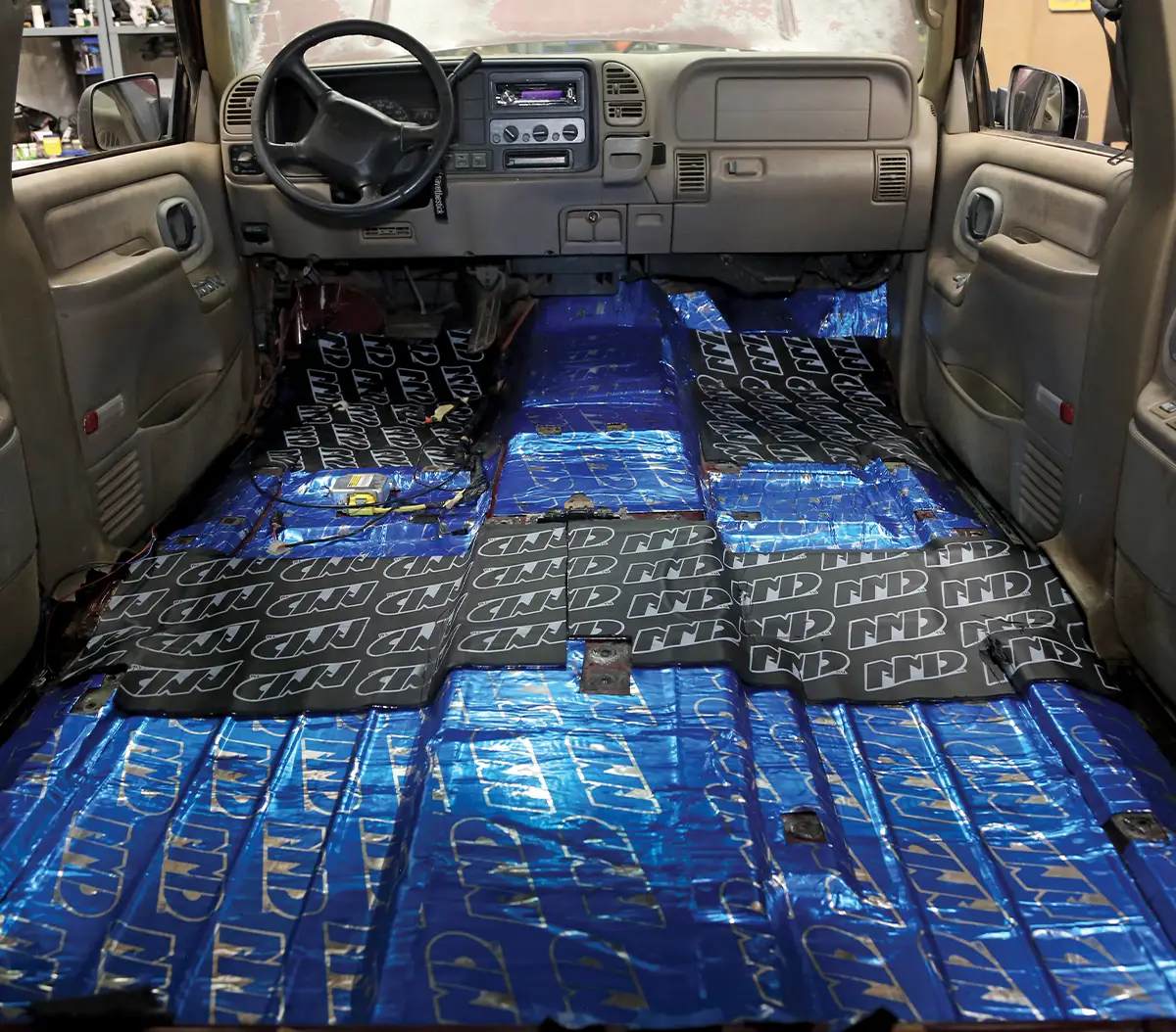 1995 Chevrolet Suburban applying NDP sound mat with roller for tight seal