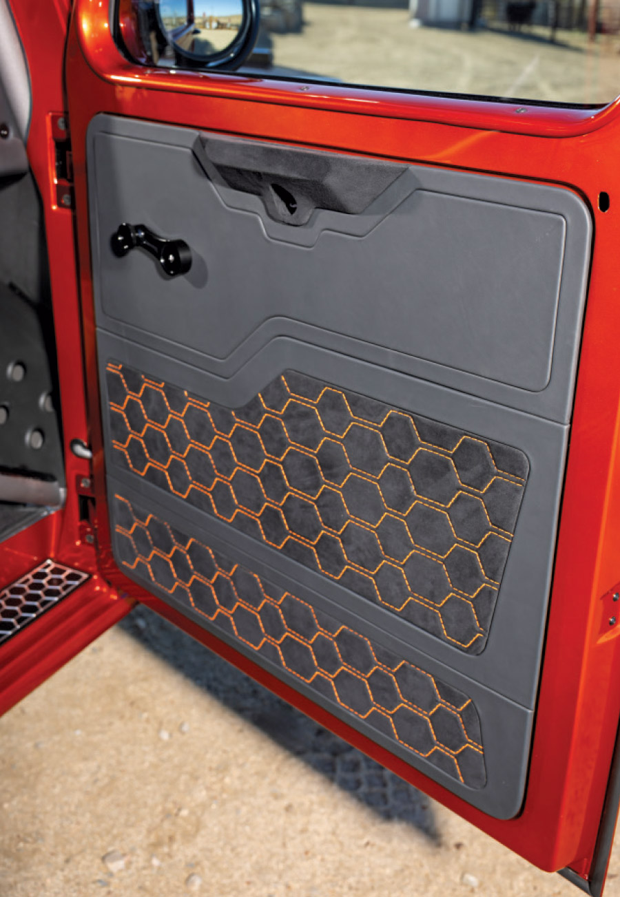 1949 Willys custom door panel featuring gray upholstery with orange honeycomb-pattern stitching and vintage-style door handle