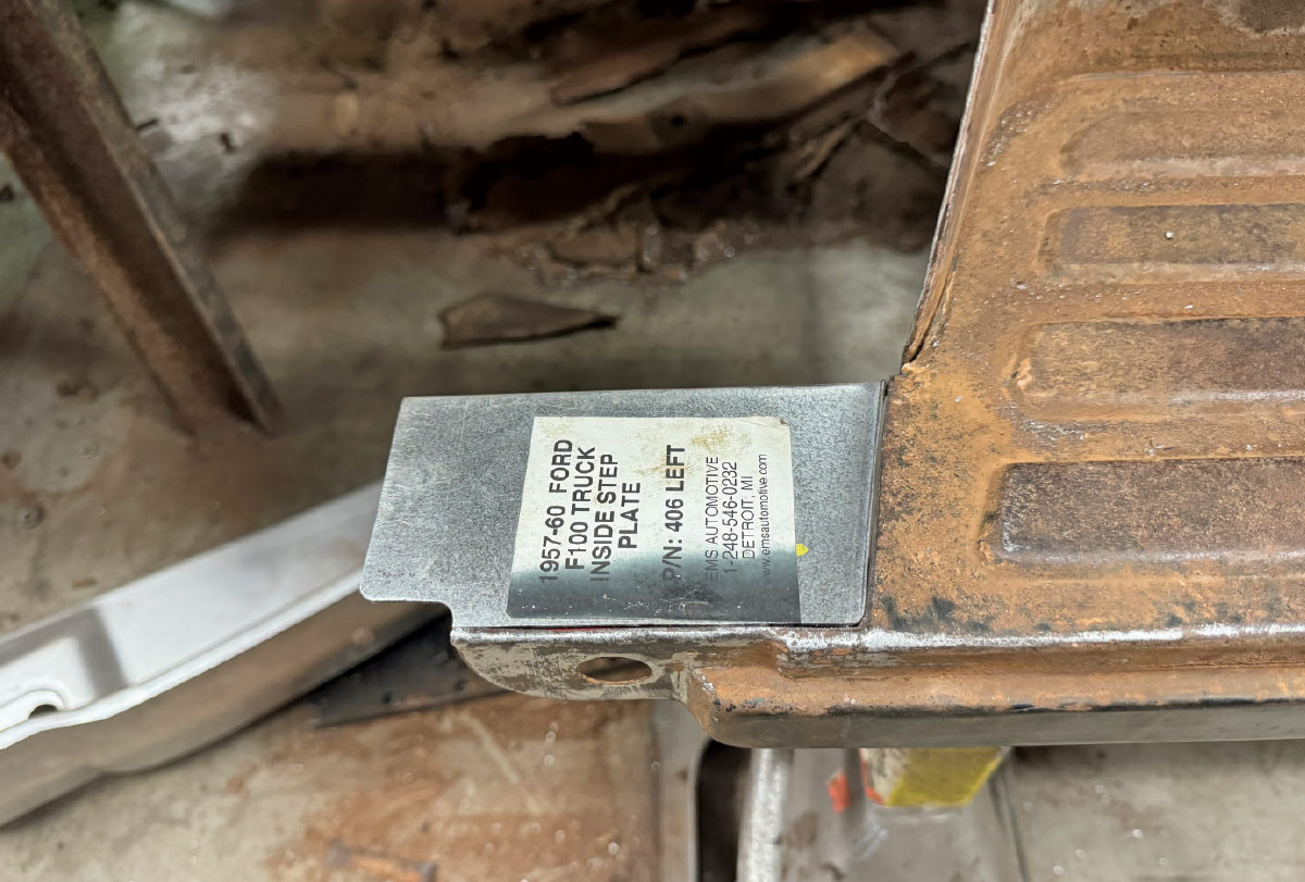 A new steel replacement "inside step plate" for a 1957-60 Ford F100 truck held against the rusted original part.