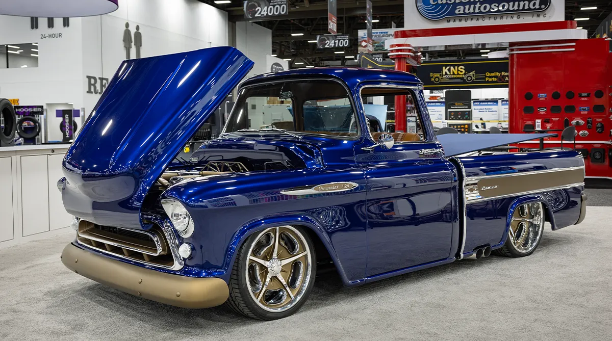 A high-angle interior shot of a classic truck restoration project, featuring newly fabricated and welded raw steel floor pans and a raised transmission tunnel to accommodate a modern drivetrain upgrade