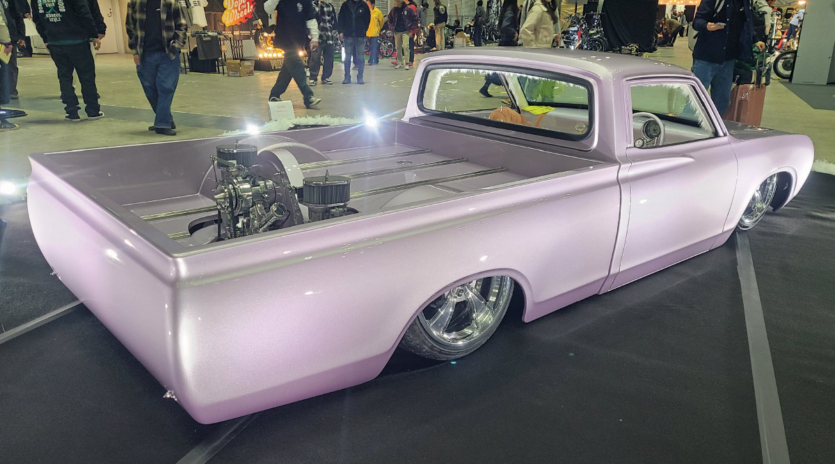 Lavender pearl slammed custom pickup truck rear three-quarter view indoor car show display with polished engine setup