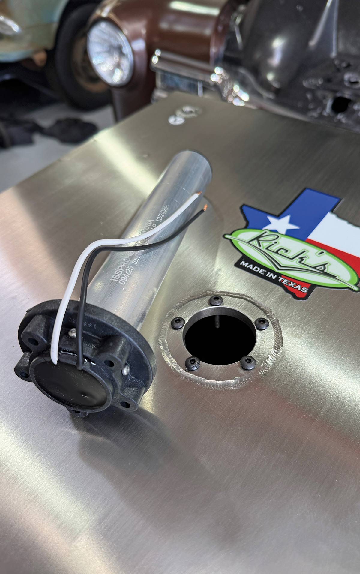 ISSPRO fuel sending unit resting on the tank next to the mounting port.