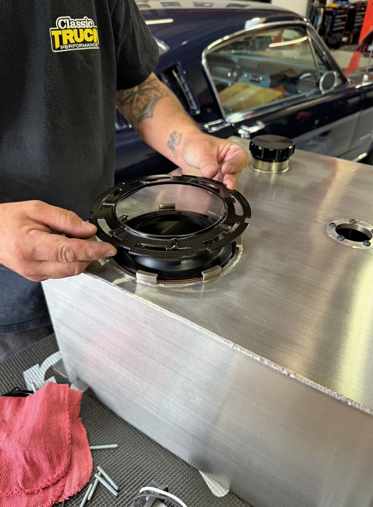 Placing the black anodized mounting flange onto the fuel tank opening.