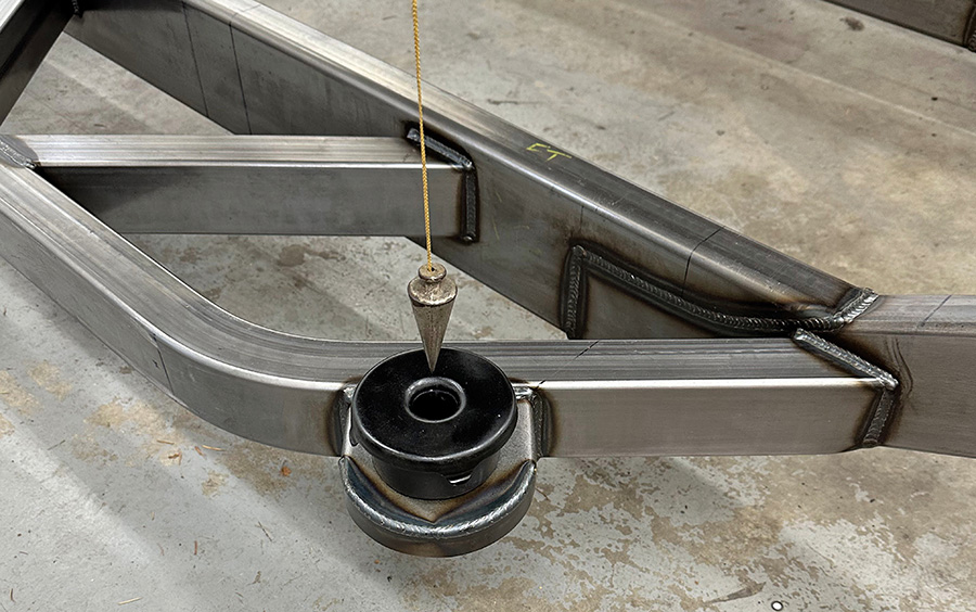 Plumb bob verifying proper alignment of chassis mounts.
