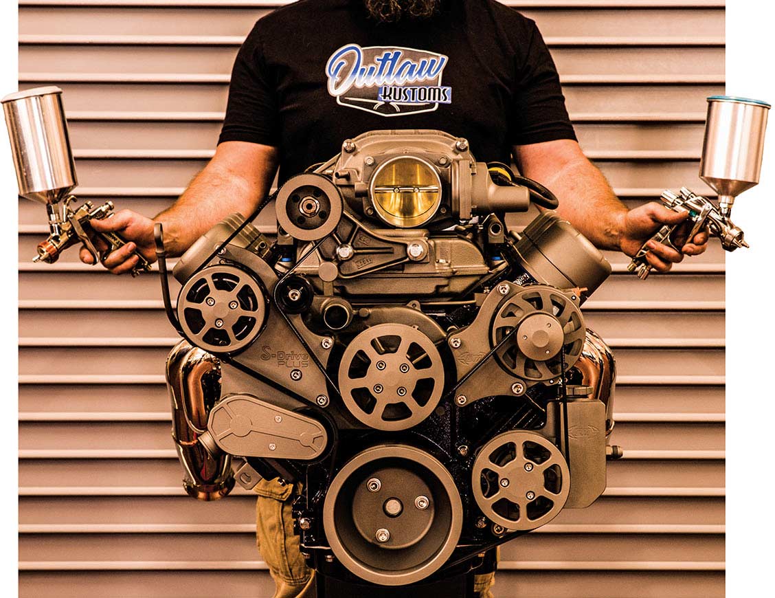 A custom engine with a person holding two spray paint guns.