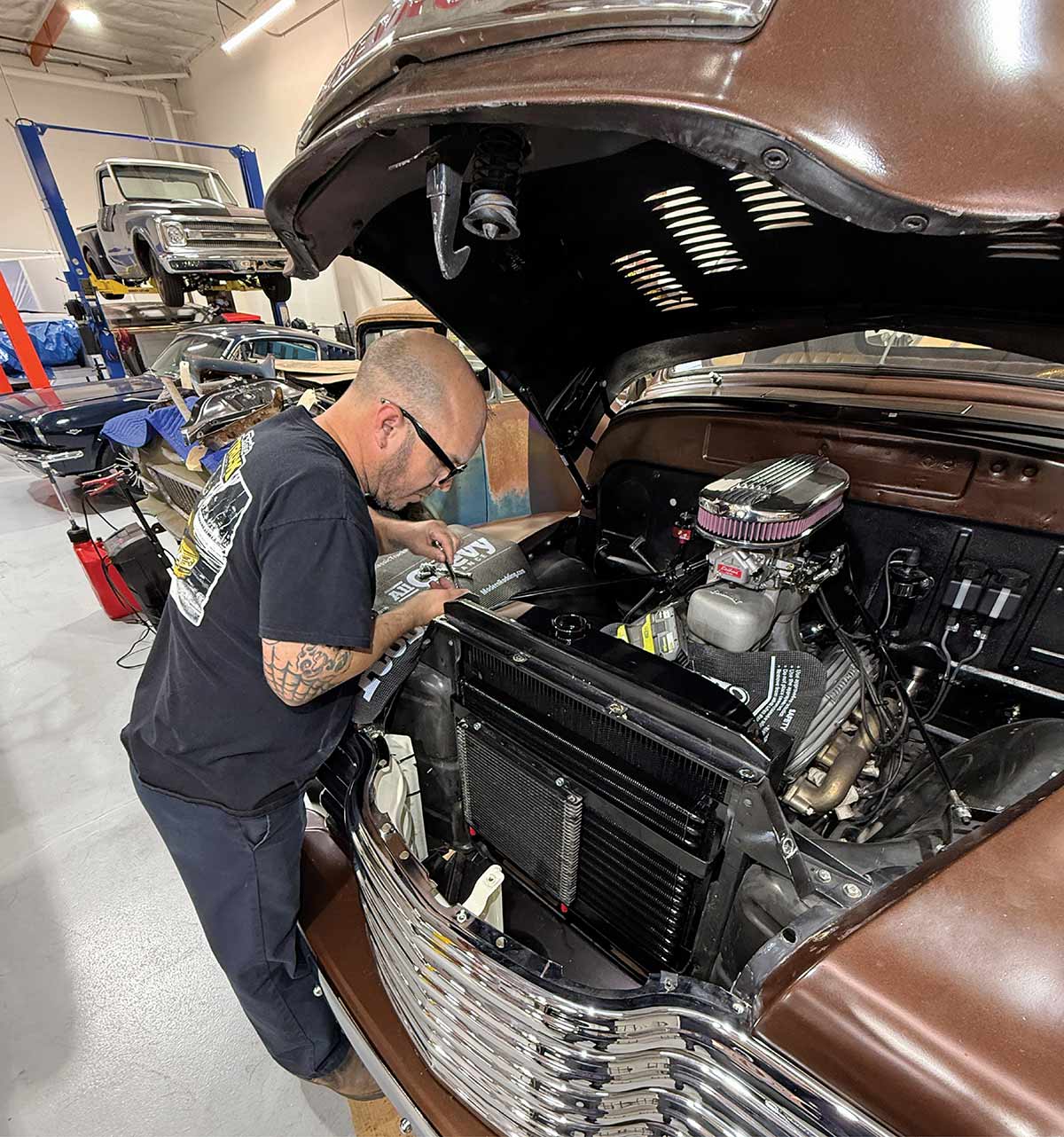 Mechanic working in the engine bay of a truck.