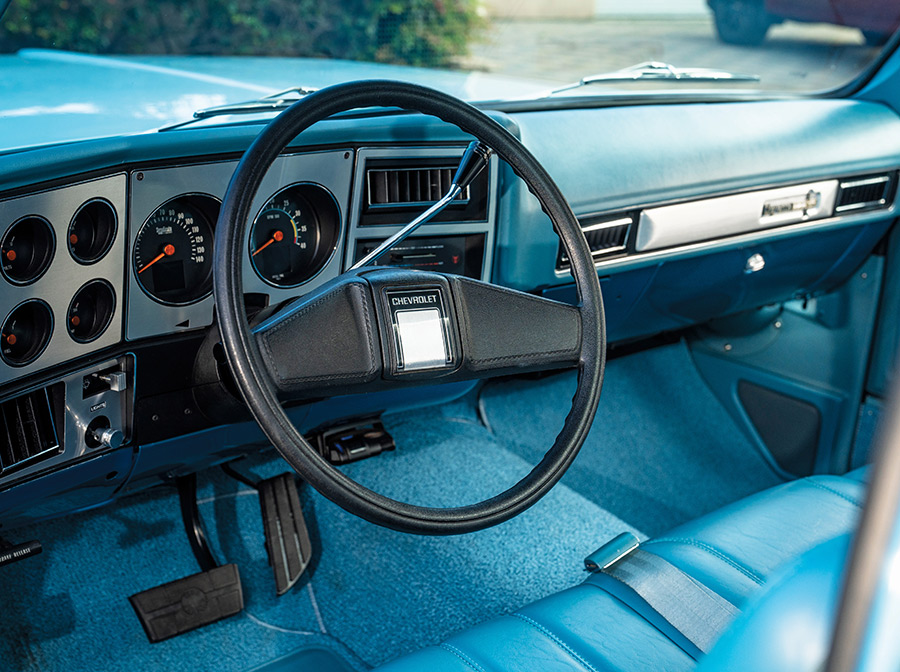 Clean blue dashboard with factory style steering wheel.