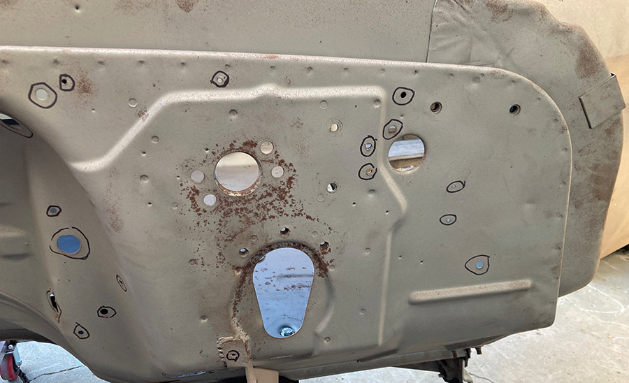 Lower section of firewall with identified holes for filling