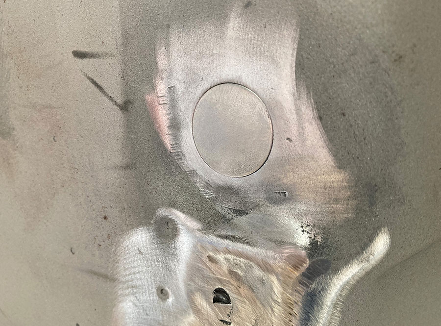 Steel filler disc positioned over a firewall hole