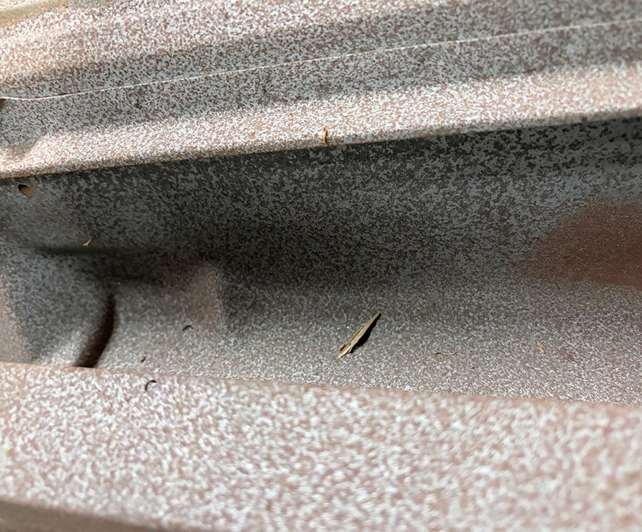 Surface rust in a narrow, hard-to-reach metal channel.