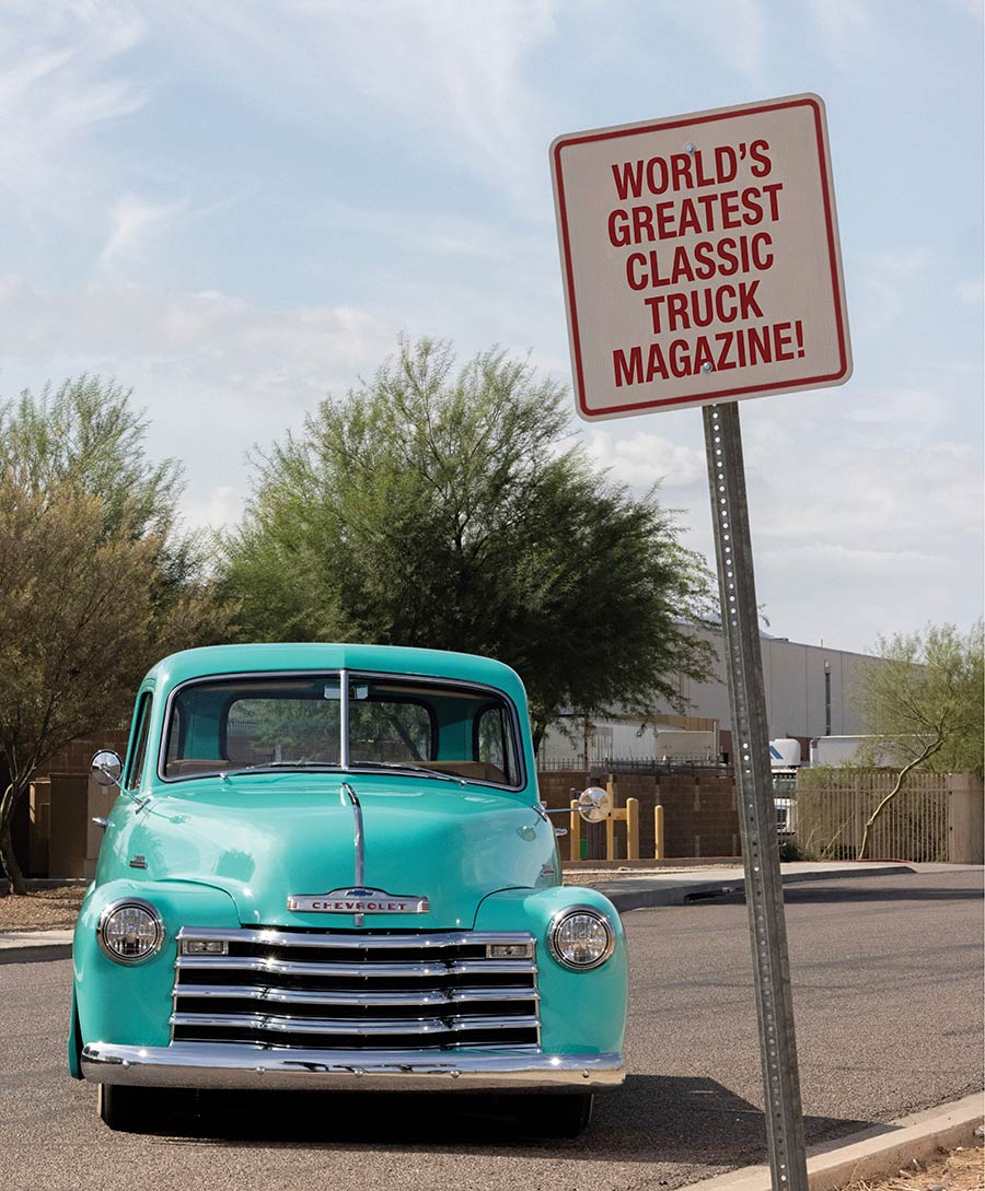 Head-on view of the classic Chevy next to a sign.