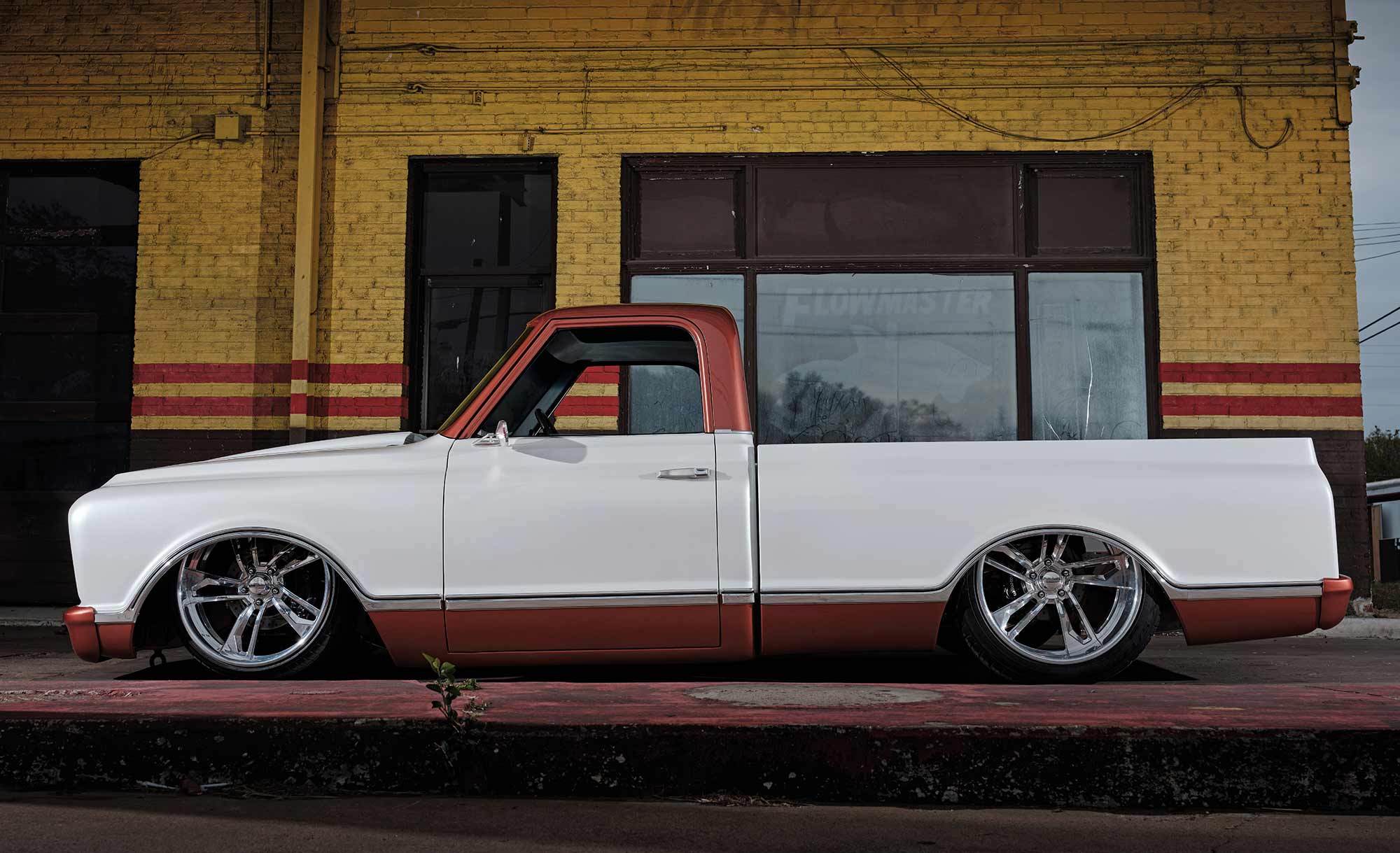 Profile view of slammed white and copper 1968 Chevy Fleetside.
