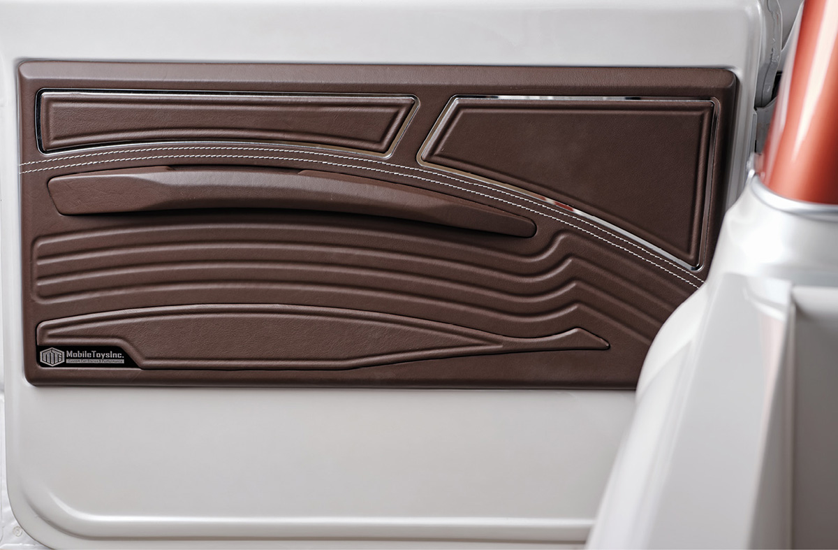 Sculpted Woodsmoke Relicate leather door panel with stitching.