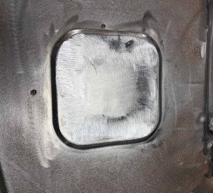 Finished metal patch blended into the firewall.