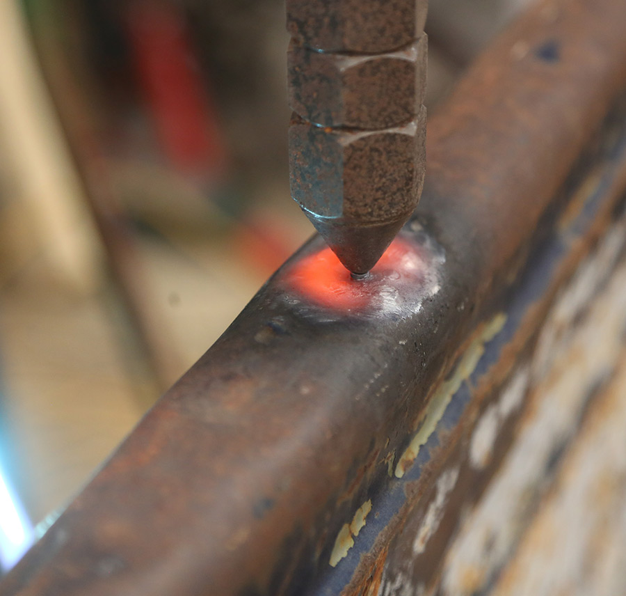 Using a torch to apply heat to dented metal.