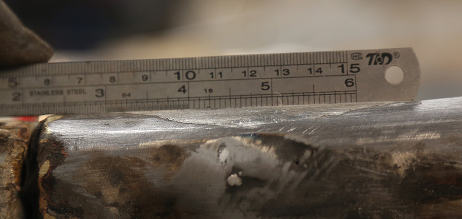 Verifying a flush repair using a metal straightedge.