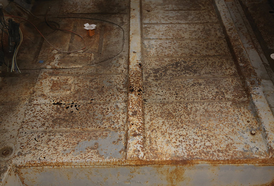 View of rusted and pitted truck floor pans.