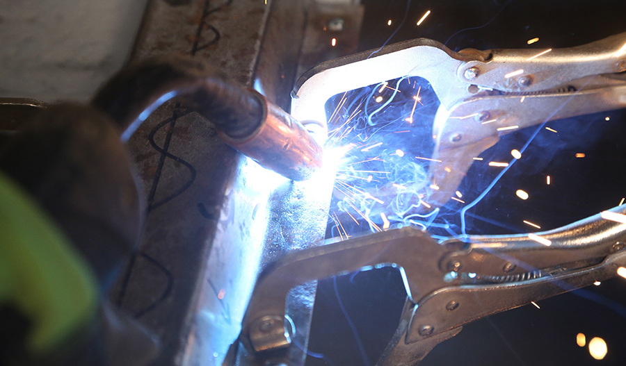 Welding the new center brace into the cab floor.